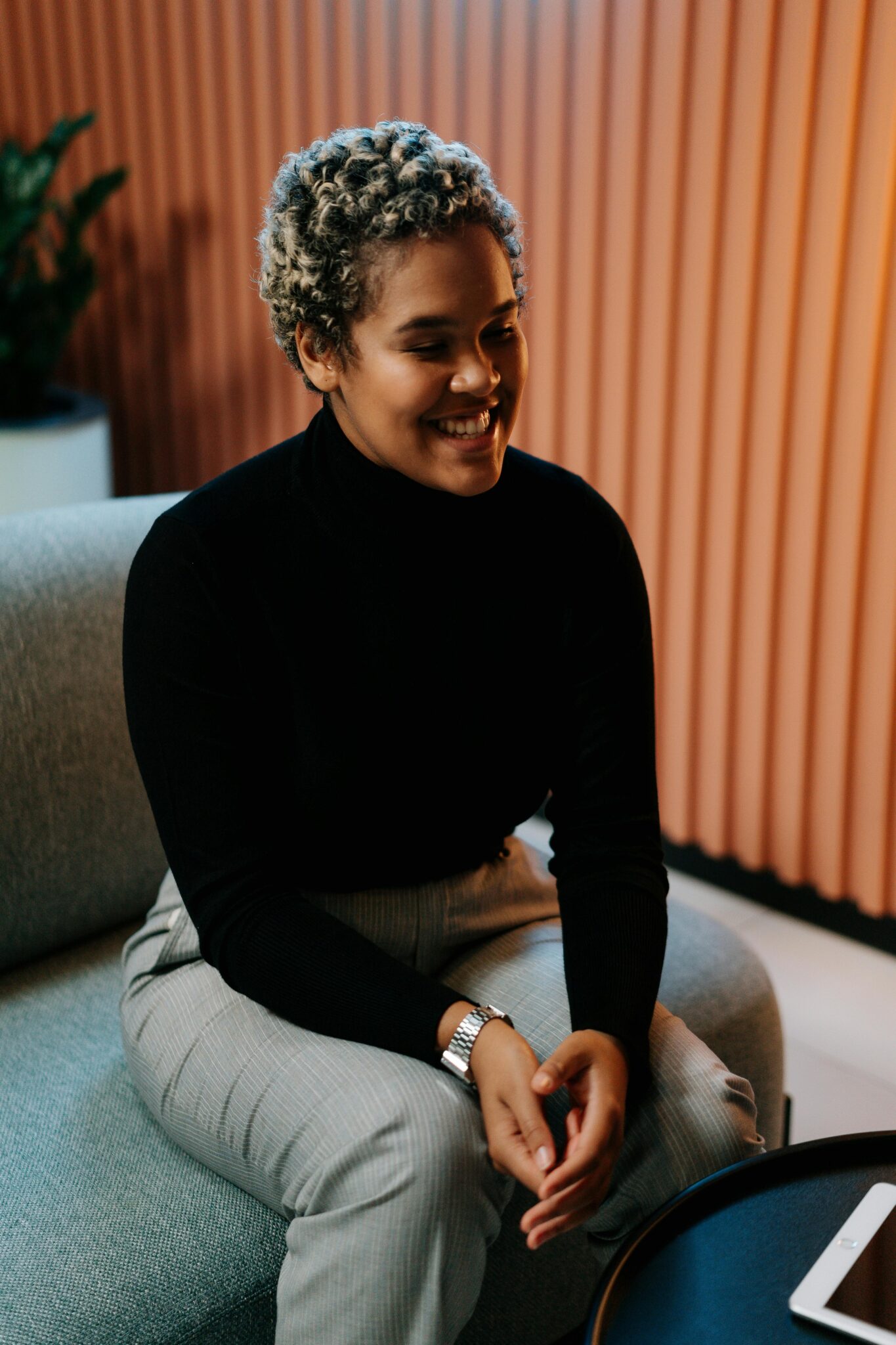 Charming businesswoman sitting in a modern office, smiling confidently during a professional meeting.